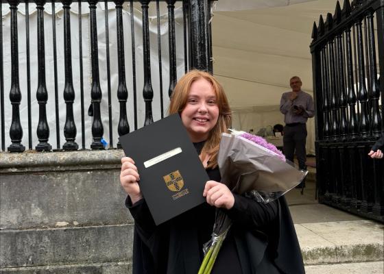 Lauren Court holding her degree certificate outside senate house