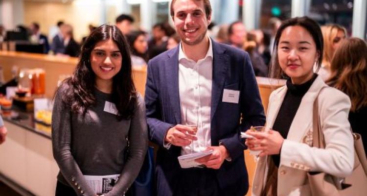Photo of three event guests posing holding a drink
