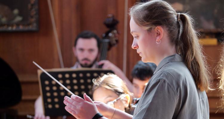 Emily Clare-Hunt directing at Girton's May Week Concert