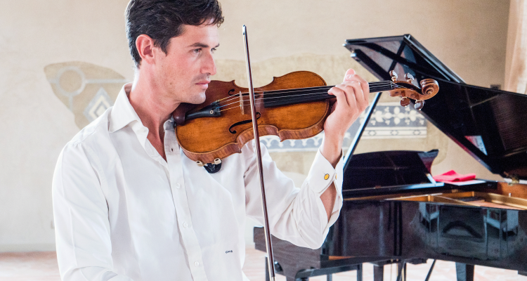 Charlie Siem playing the violin infront of a piano