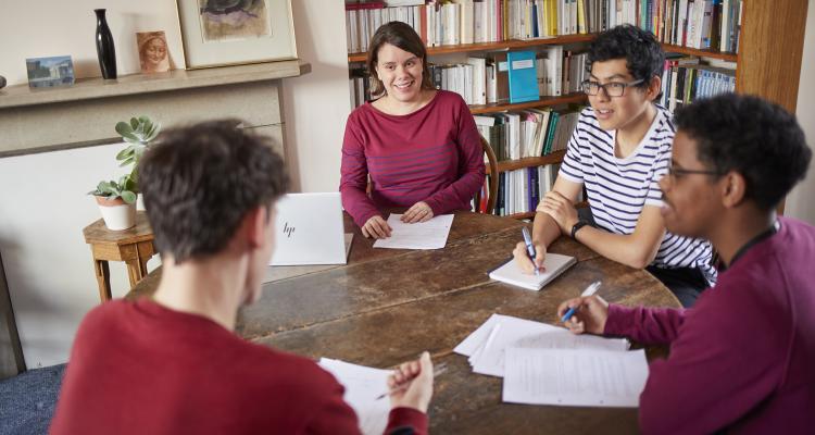 3 students around a table with a teacher during a supervision