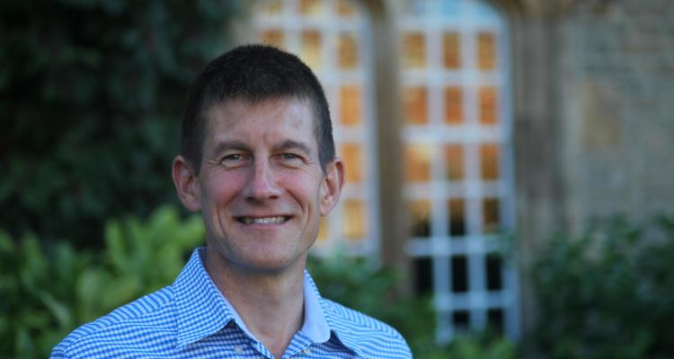 Dr Shaun Fitzgerald in front of blurred background of a outside window