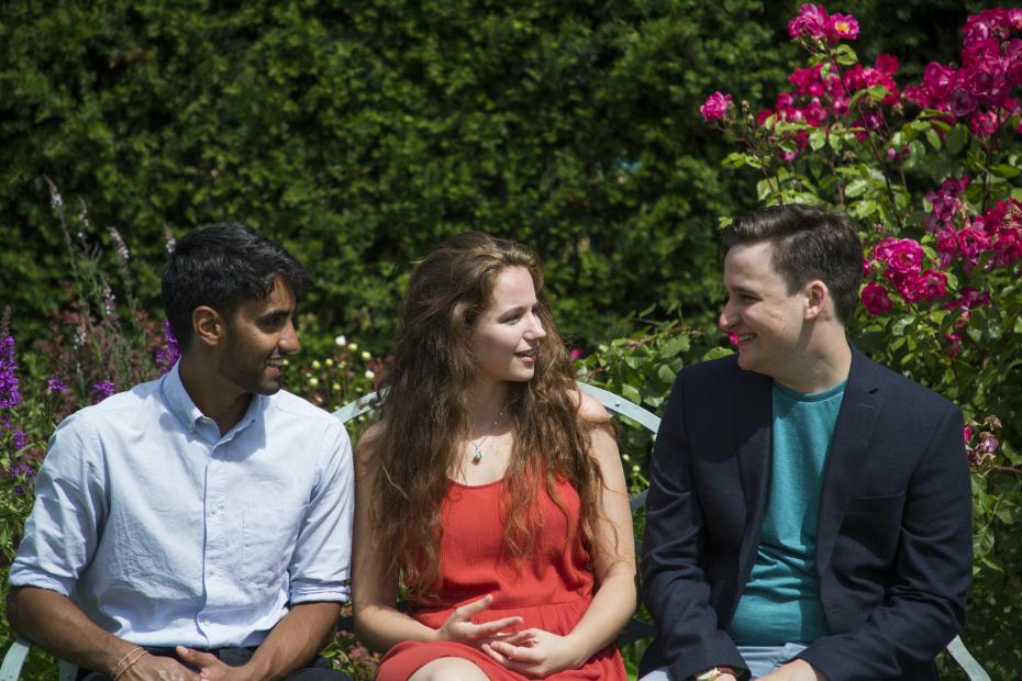 Students talking while sitting on a garden bench