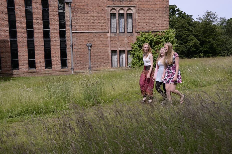 three girls walking in the College grounds