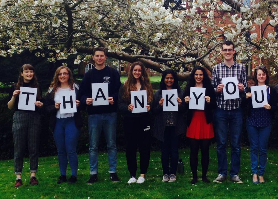 Students holding signs with a letter, spelling the word Thank You